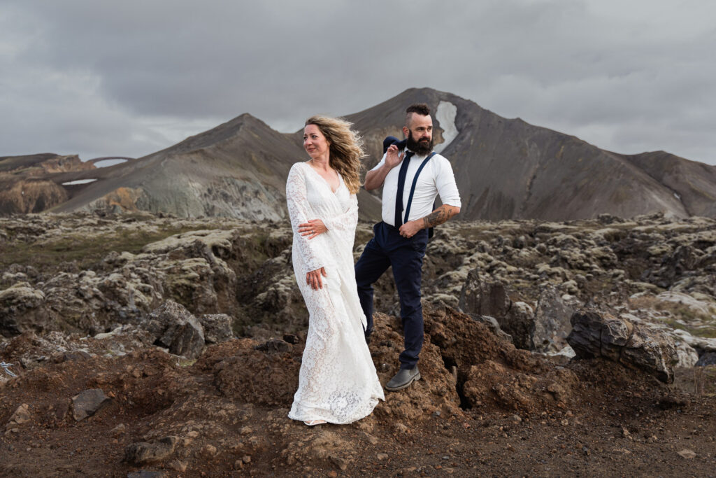 Bride and groom at their eco-friendly elopement looking in opposite directions with Landmannalaugar around them