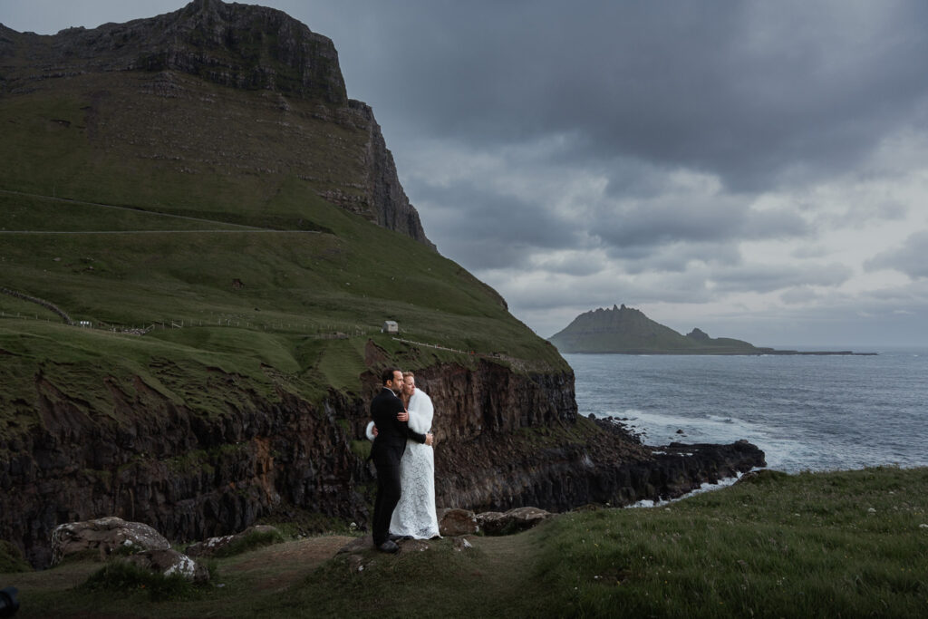 Bride and groom embracing each other during blue hour at Múlafossur for their Faroe Island elopement