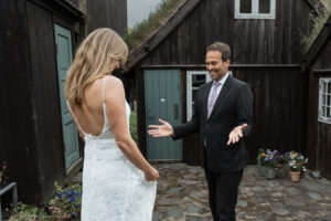 First look with bride and groom in Tórshavn at their Faroe Island Elopement. Cute, black houses with grass roofs.