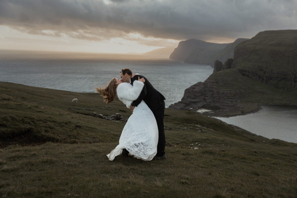 Bride and groom having an eco-friendly wedding while kissing against sunset backdrop of Traelanipa