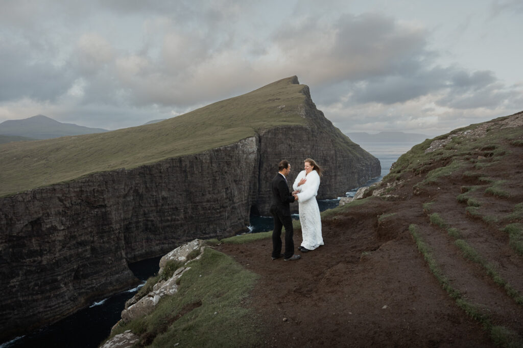 Bride and groom standing on cliff at Traelanipa Faroe Islands. They learned how to elope on the Faroe Islands from Shawna Rae Photography.