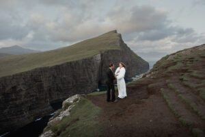 Bride and groom standing on cliff at Traelanipa Faroe Islands. They learned how to elope on the Faroe Islands from Shawna Rae Photography.