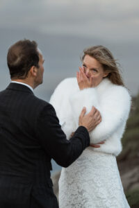 Bride wiping tears emotionally at Trælanípa after groom says his vows on Faroe Island