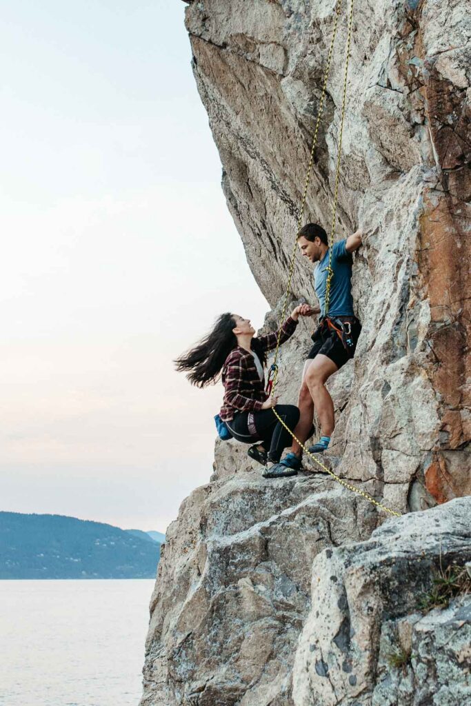 Rock climbing elopement in Lighthouse Park with bride and groom swinging on the rope. Things to do on your elopement day.
