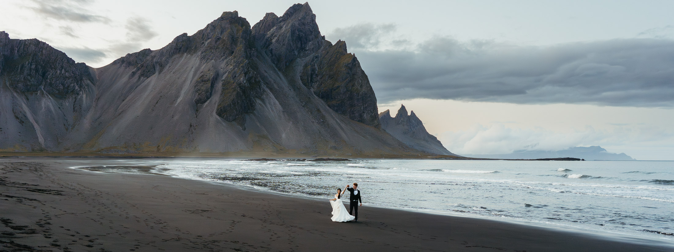 Bride and groom dancing on Stokksnes beach in Iceland during their elopement