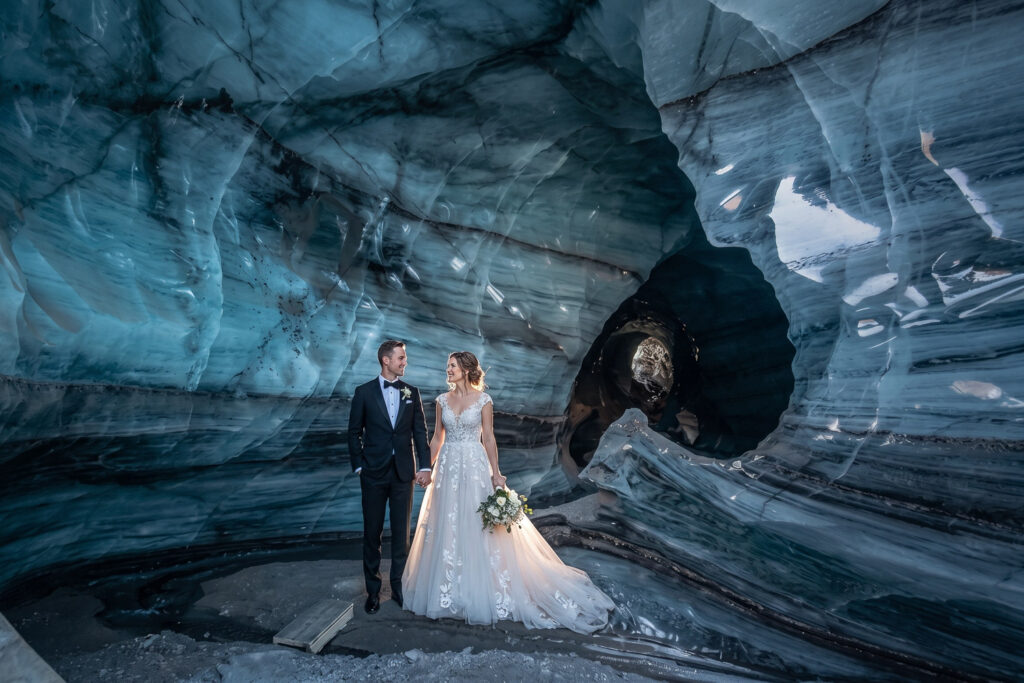 Bride and groom looking at each other in ice cave in Iceland