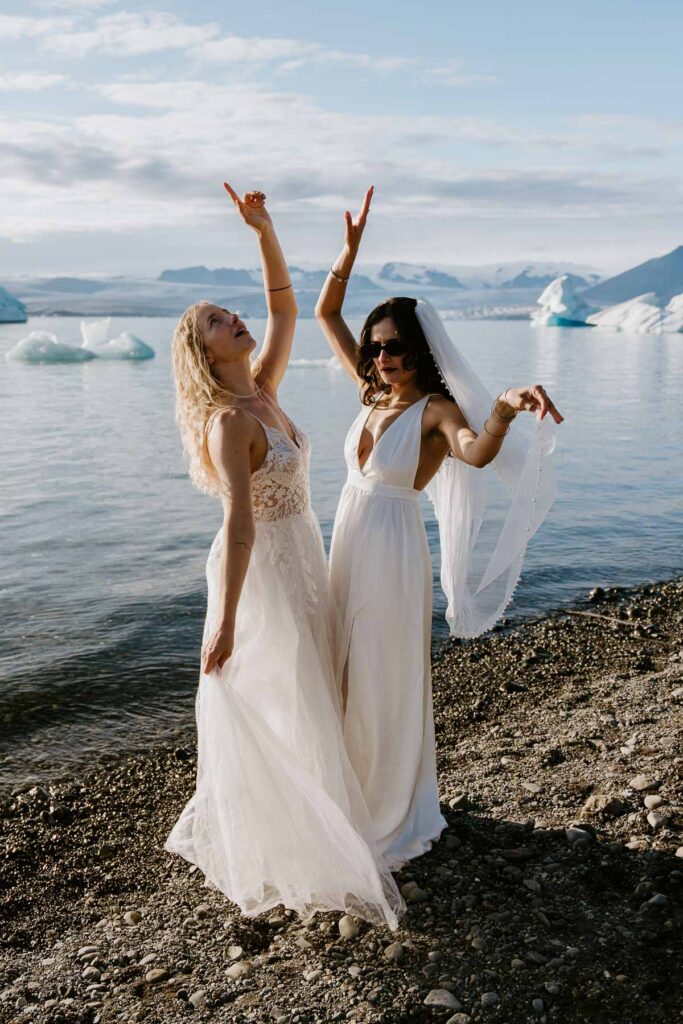 Bride and bride dancing in front of Icebergs; How to Elope in Iceland