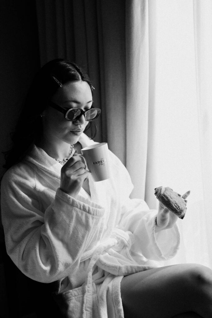 bride in black and white holding a croissant and coffee; How to Elope in Paris