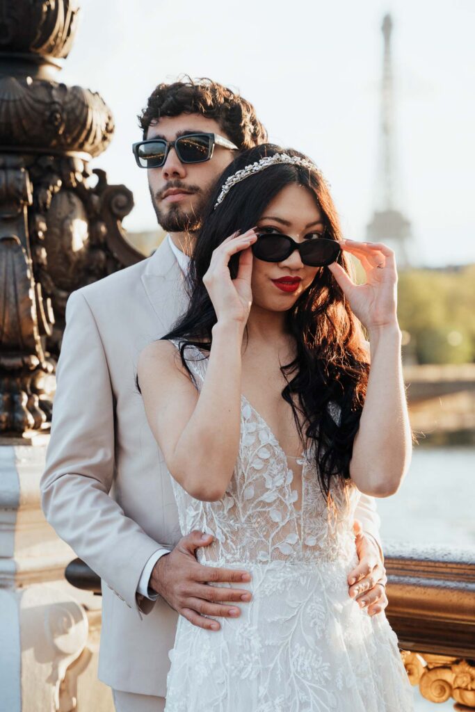 Bride and groom with sunglasses at Pont Alexander III bridge at sunset; How to Elope in Paris
