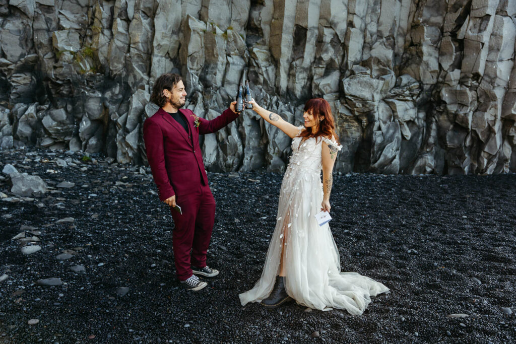 Bride and groom cheering with Icelandic beers; How to Elope in Iceland