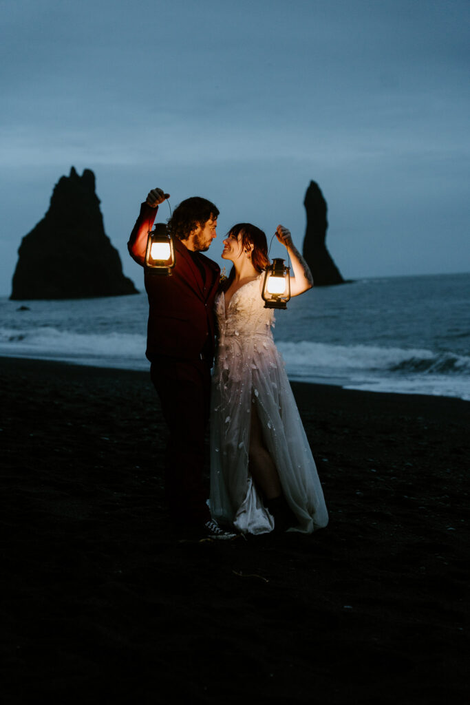Bride and groom with lanterns in Iceland on Reynisfjara. Best place to elope in Iceland