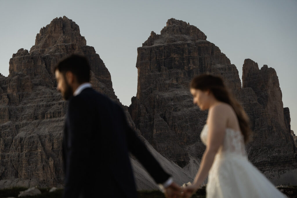 Tre Cime with an eloped couple walking in front f the peaks; Best Places to Elope on a Mountain in Europe