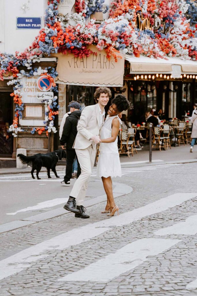 Bride and groom dancing on the street in Paris in front of Vrai Paris; How to Elope in Paris